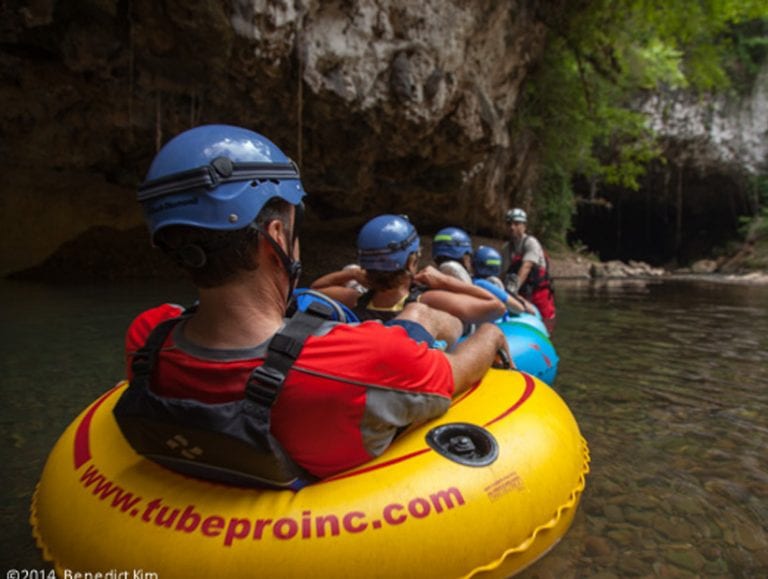 man going cave tubing - belize cave tours