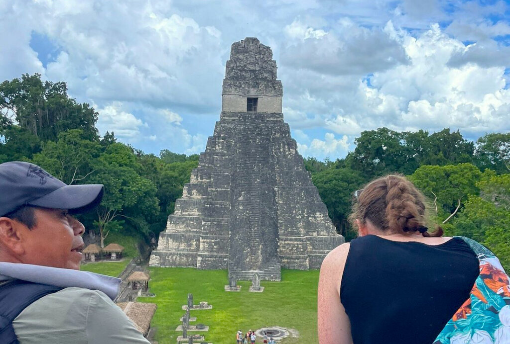 Pacz Tours guide Hugo talking with a traveler while looking at Tikal Temple in Guatemala