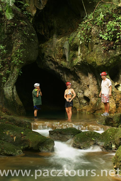 Pacz Tours guide and couple standing at the entrance of Belize’s ATM Cave, gateway to the Maya underworld Xibalba